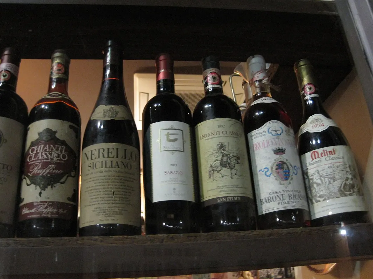 Bottles of Italian red and white wine on a cellar shelf